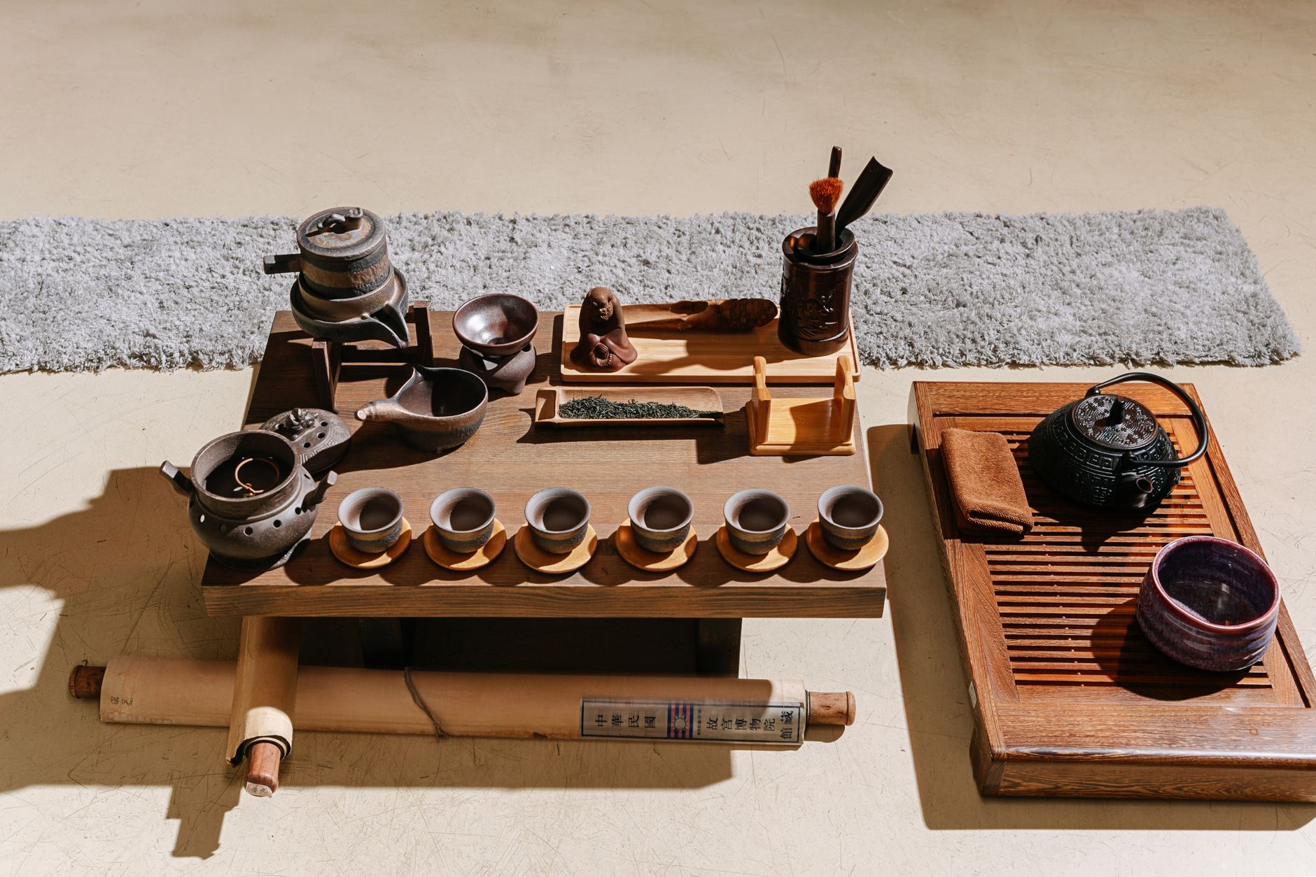 Tea ceremony setup with teapot and cups on a wooden table