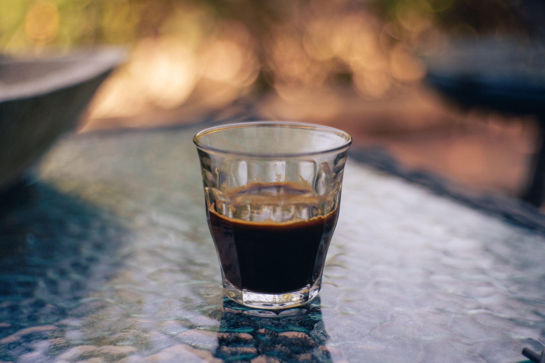 Small glass cup of espresso-based coffee on an outdoor table