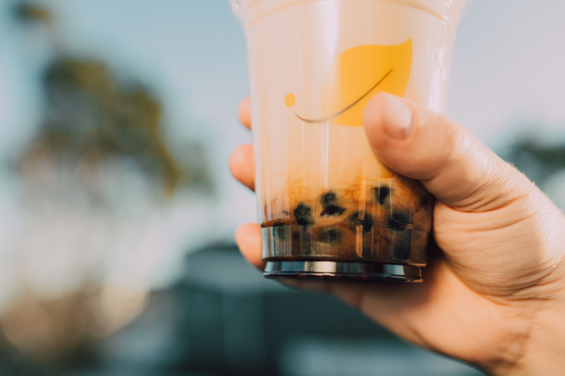 Hand holding a bubble tea cup with tapioca pearls