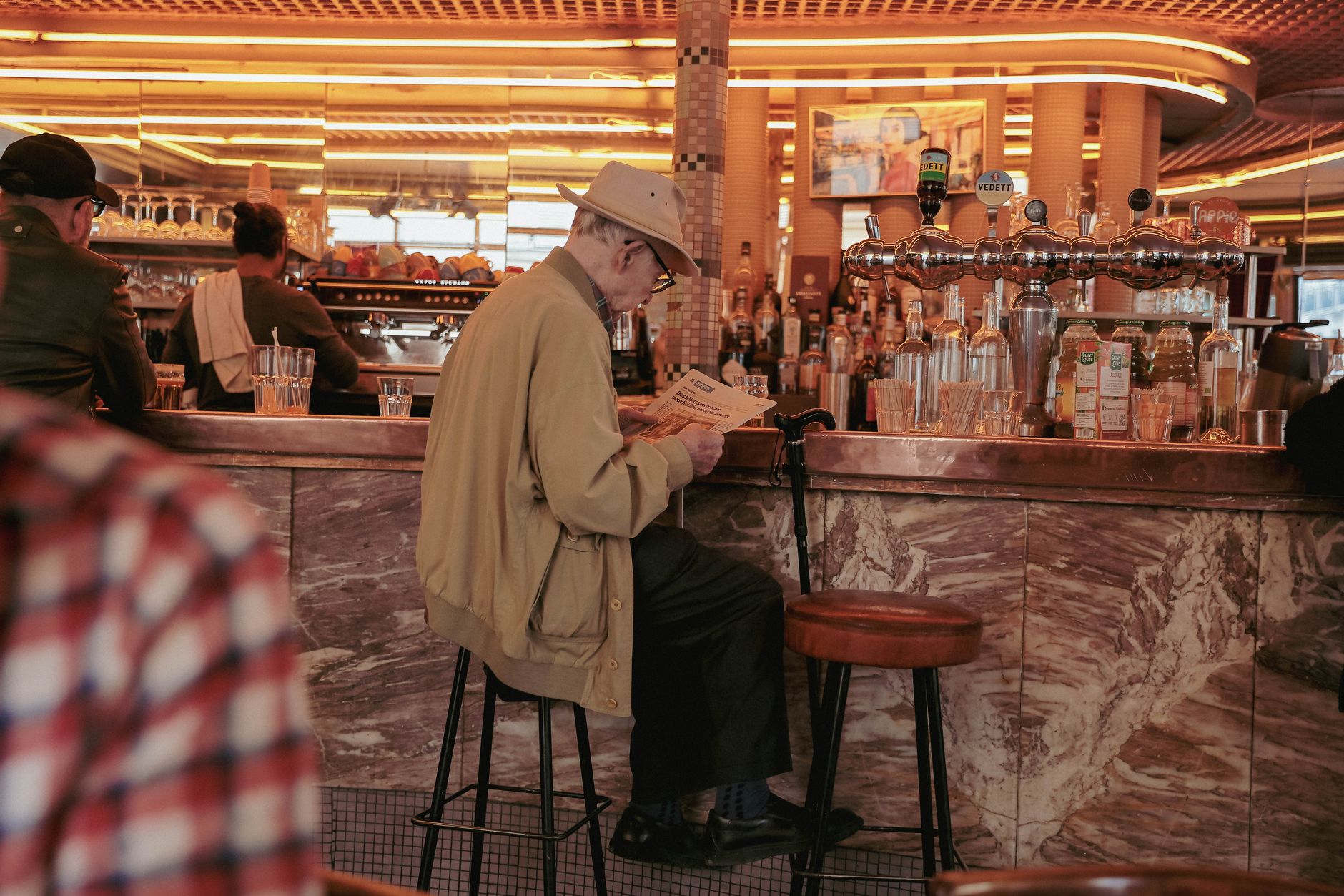 A man reading a newspaper at a diner counter