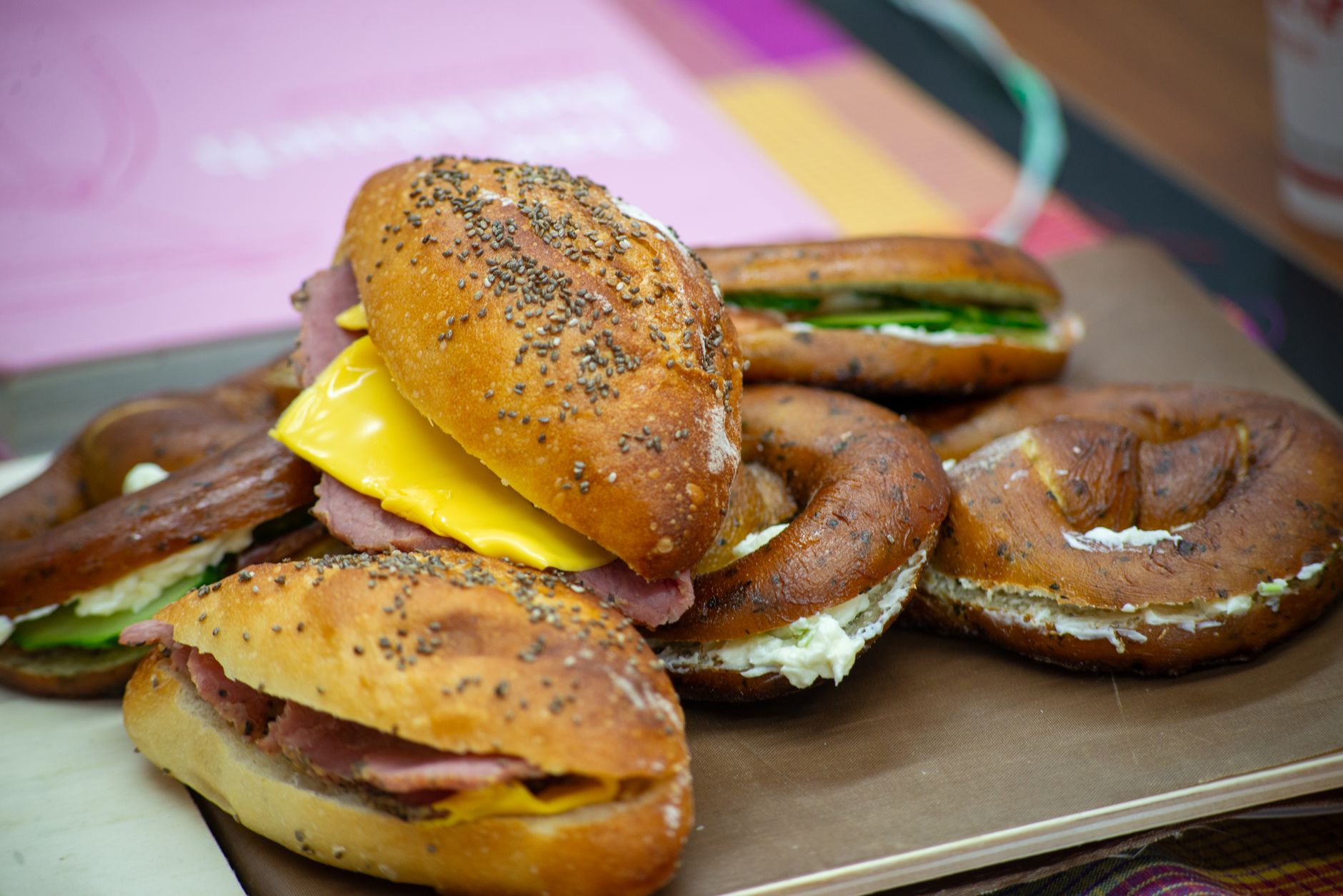 Assorted bagels with ham, cheese and cream cheese on a tray