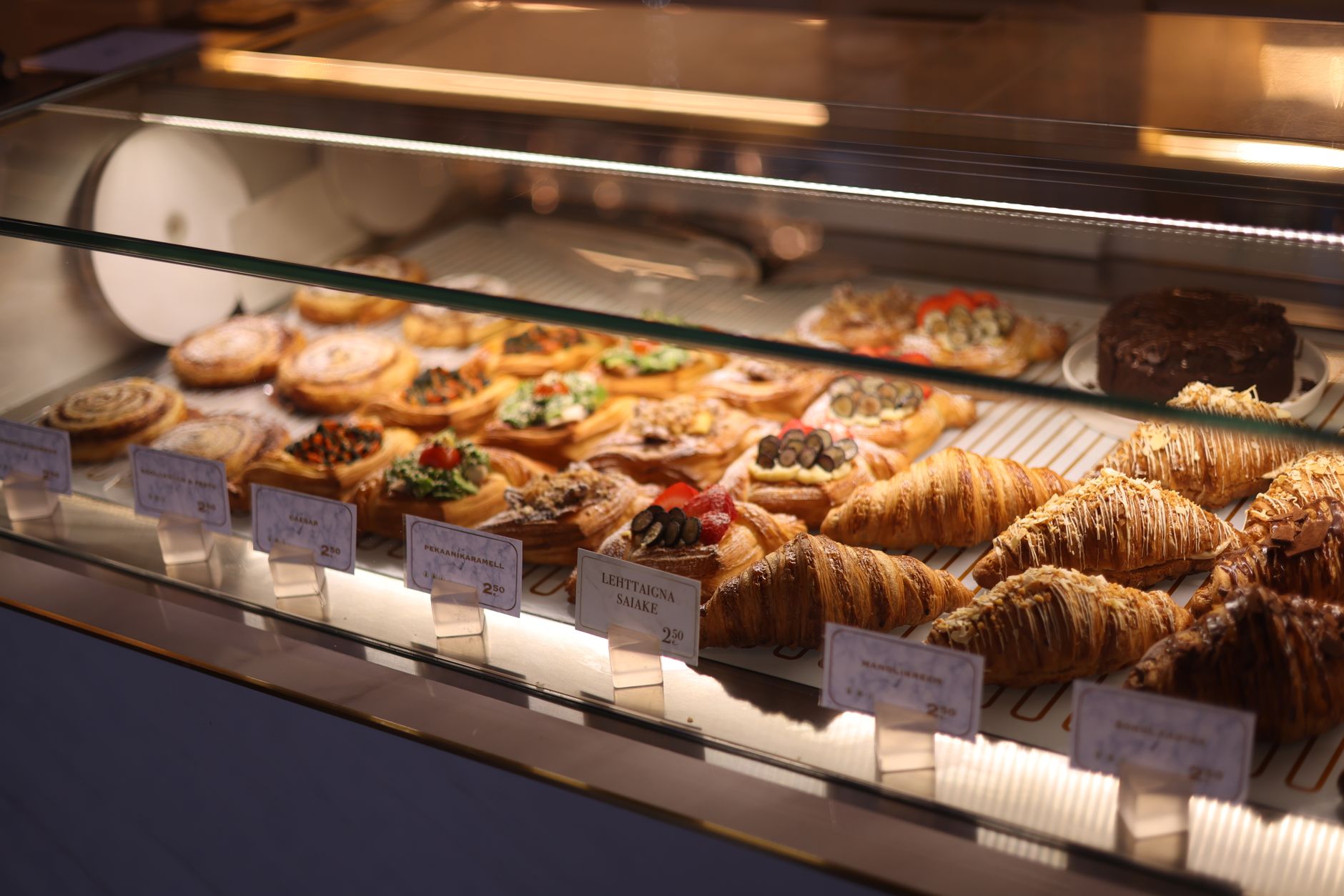 Assorted pastries and croissants displayed in a bakery showcase